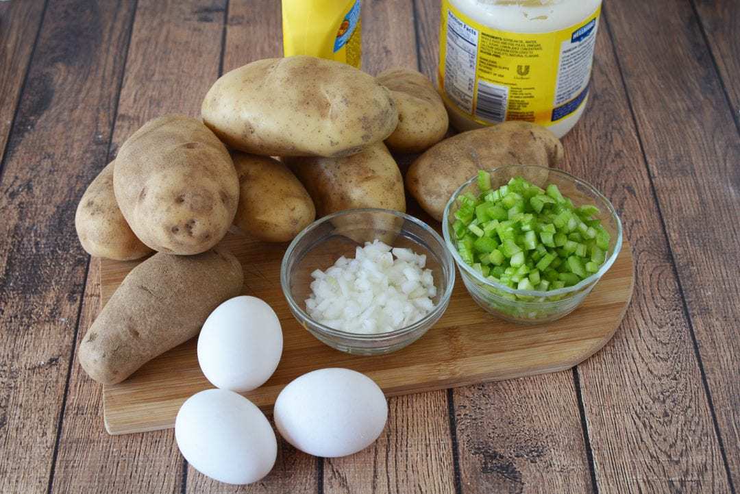 ingredients for potato salad, potatoes, eggs, celery, onion, mayonnaise, and mustard