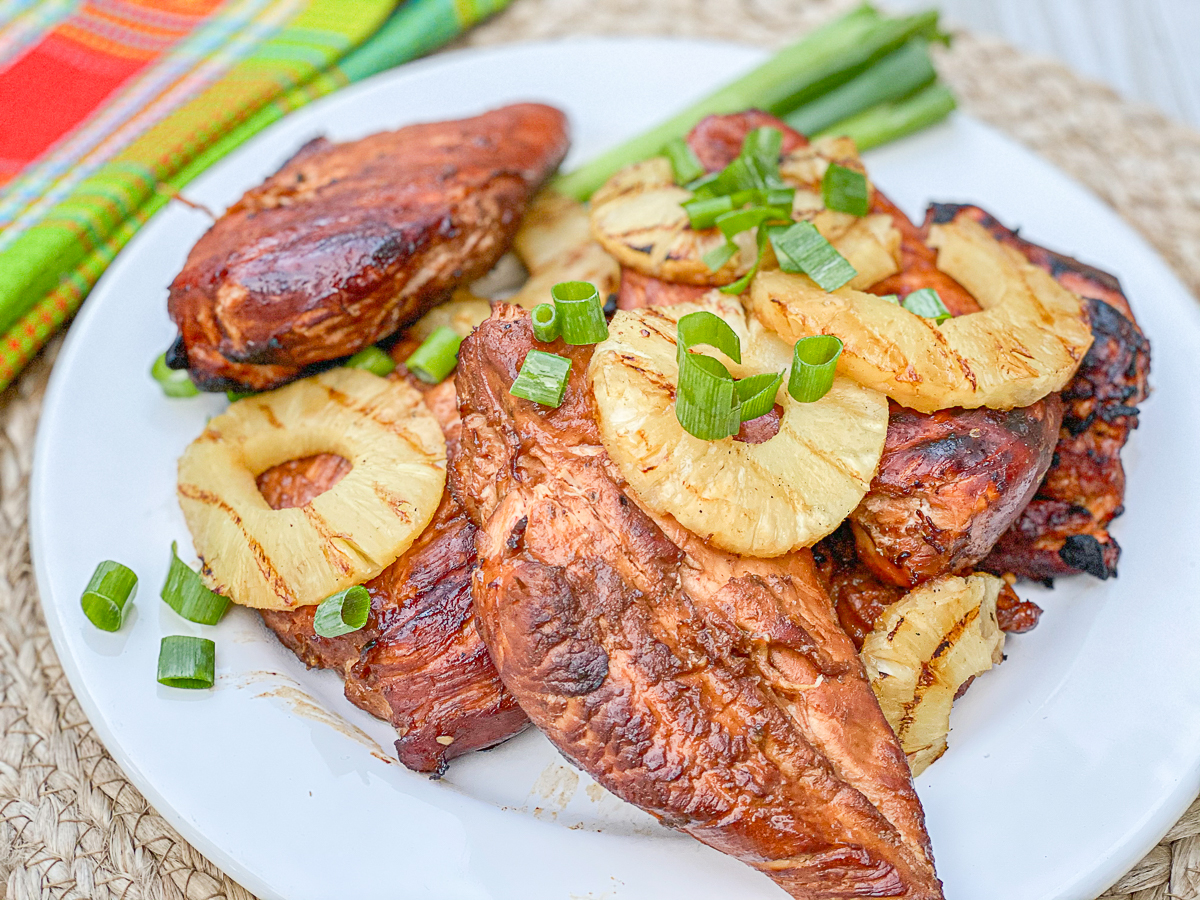 hawaiian chicken on white plate with pineapples